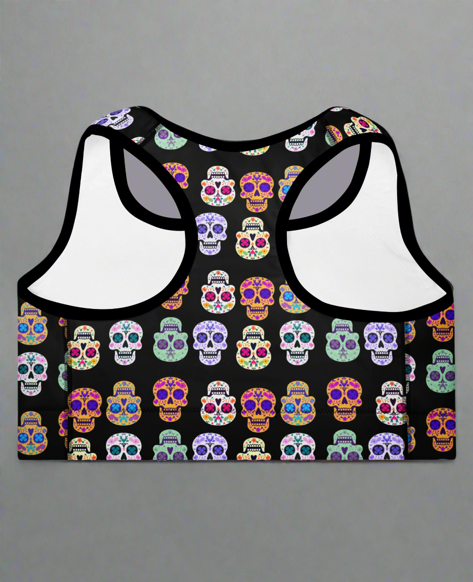 Black sports bra with colorful skull pattern on a gray background