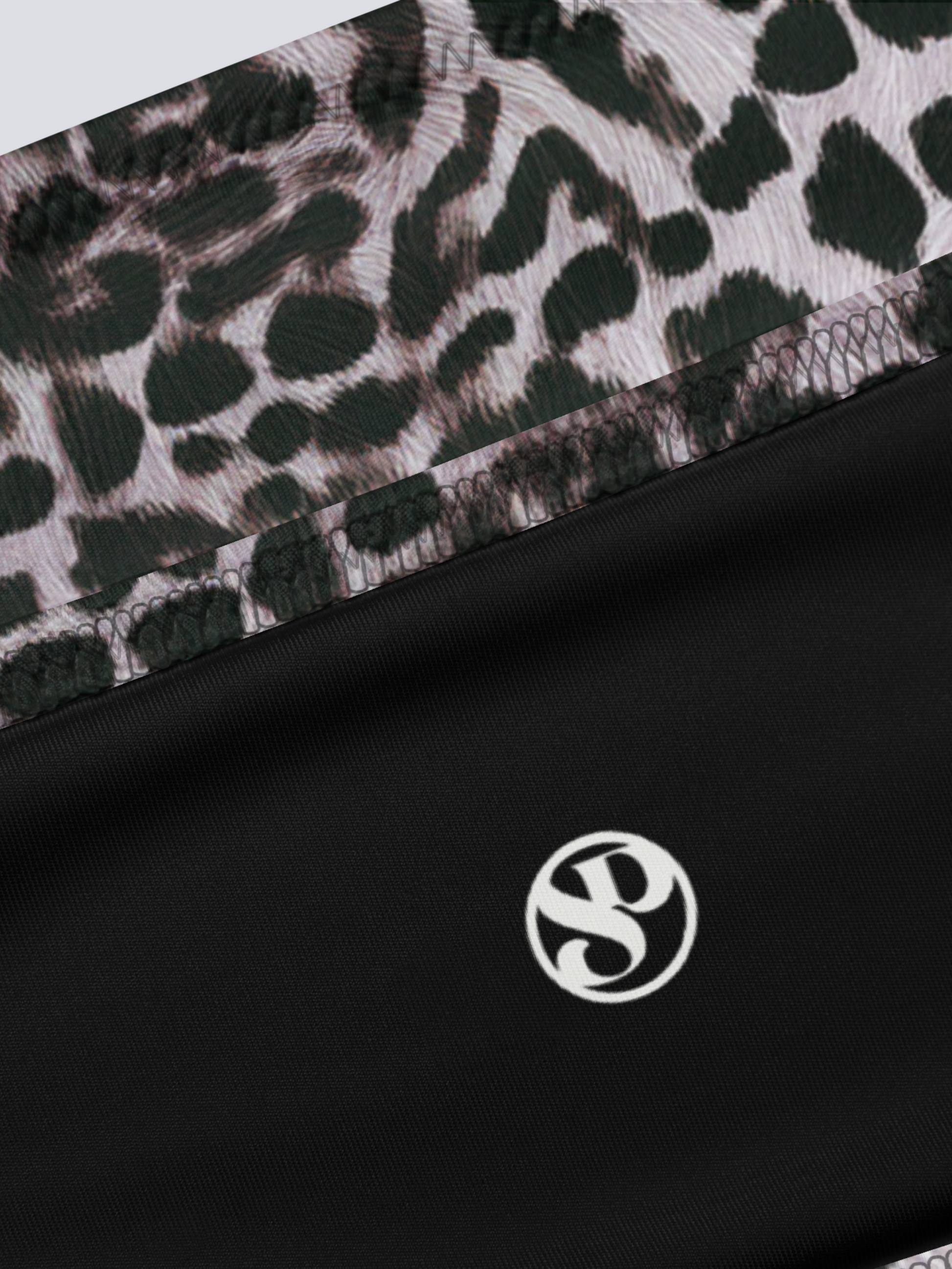 Black fabric with a leopard print pattern and a logo on a black background