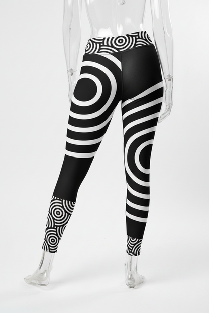 Black and white patterned leggings with concentric circle and striped optical illusion designs, shown on a model from the back against a white background.
