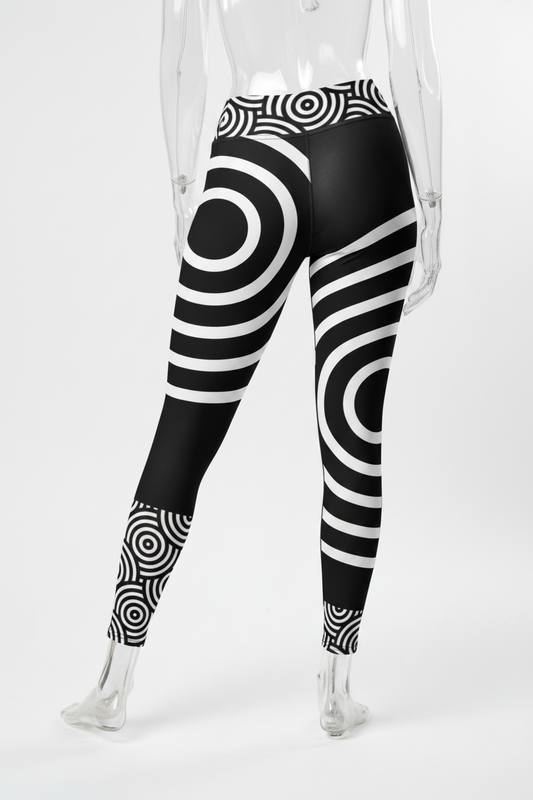 Black and white patterned leggings with concentric circle and striped optical illusion designs, shown on a model from the back against a white background.