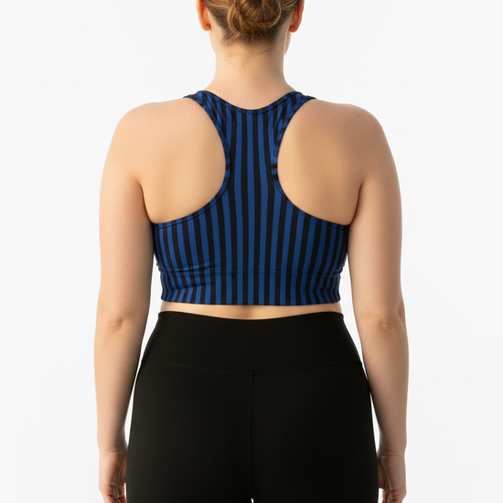 Person wearing a blue and black striped sports bra and black leggings on a white background