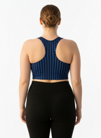 Person wearing a blue and black striped sports bra and black leggings on a white background