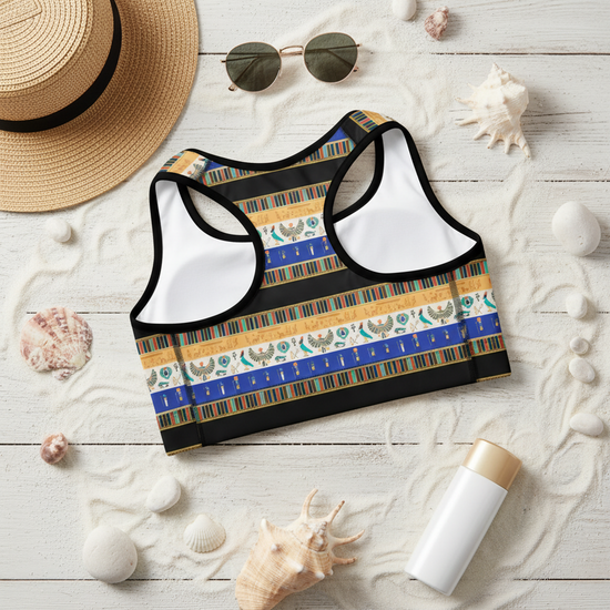 Patterned sports bra on a wooden surface with a hat, sunglasses, and lotion.