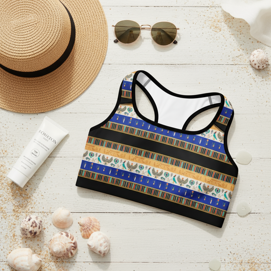 Colorful sports bra with beach accessories on a wooden surface