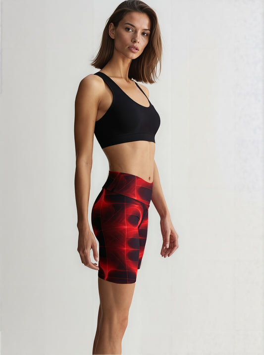 Side view of a woman wearing Blaze Ignite Yoga Shorts with a vivid red and black abstract pattern, paired with a black sports bra, standing against a plain background.