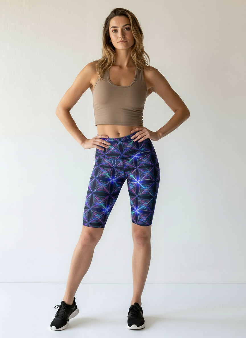 Woman wearing a brown tank top and colorful geometric-patterned leggings on a white background