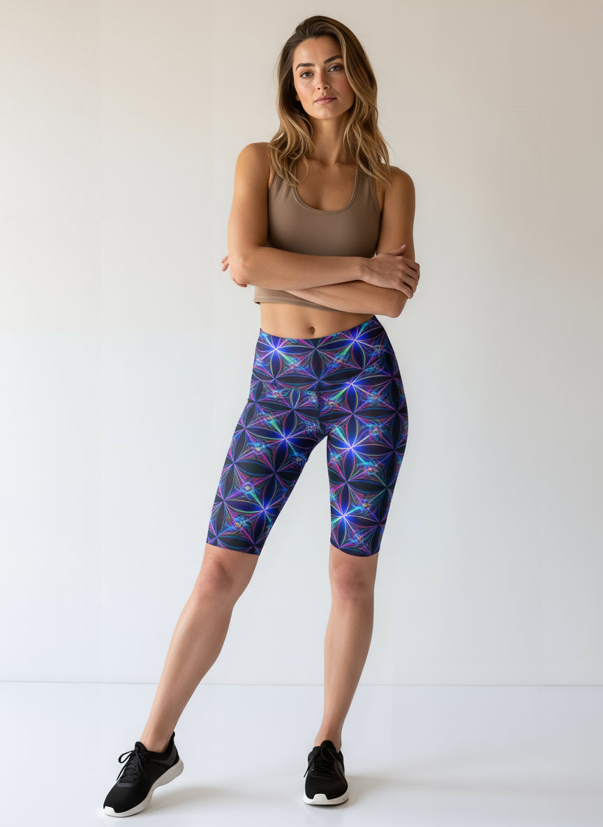 Woman wearing a brown tank top and colorful geometric-patterned leggings on a white background