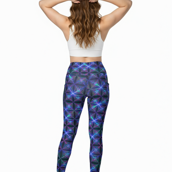 Woman wearing colorful patterned leggings and a white crop top on a white background