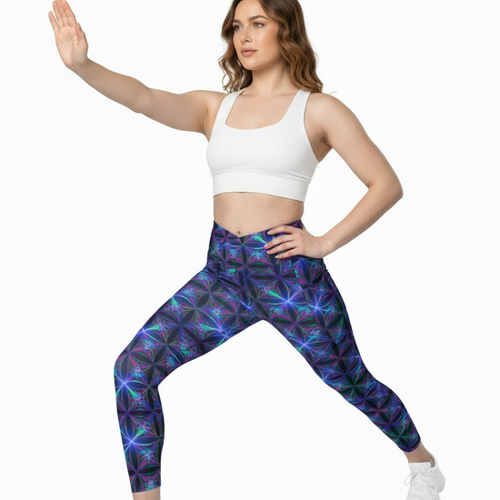 Woman wearing colorful patterned leggings and a white crop top on a white background