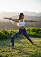 Woman practicing yoga in a field with mountains in the background