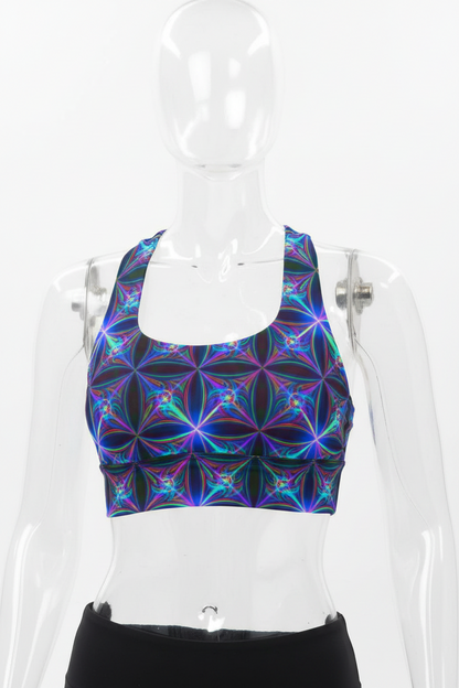 A manneqin wearing a sports bra with a vibrant, multicolored fractal floral pattern in shades of blue, purple, and green on a black base, set against a plain white background.