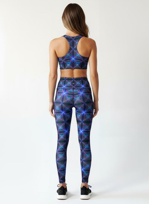 Woman wearing a blue geometric patterned sports bra and leggings on a white background