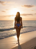 Woman in a bikini walking on a beach at sunset
