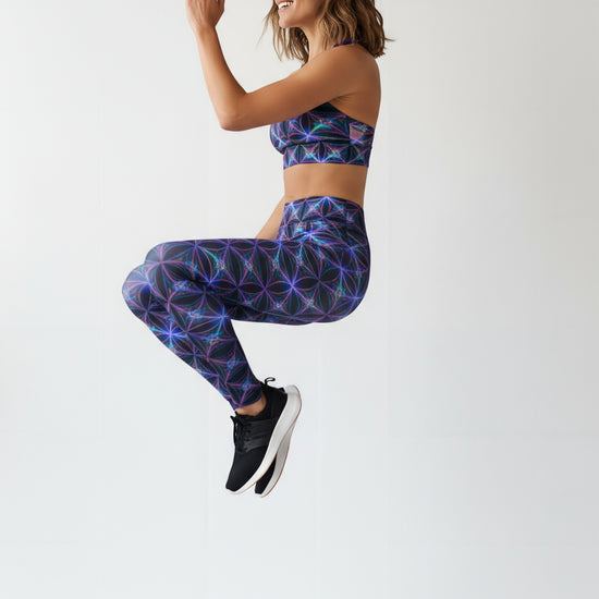 Woman wearing a colorful geometric patterned sports bra and leggings on a white background