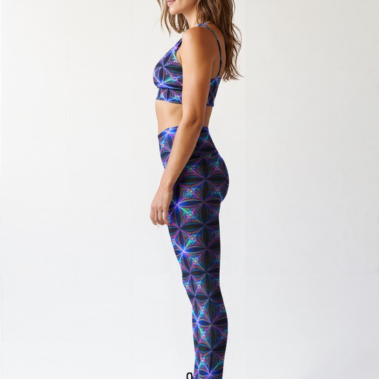 Side view of a woman wearing Blue Voltage Yoga leggings and a matching sports bra with an electric blue and purple geometric print, paired with black athletic shoes, standing against a plain light background.