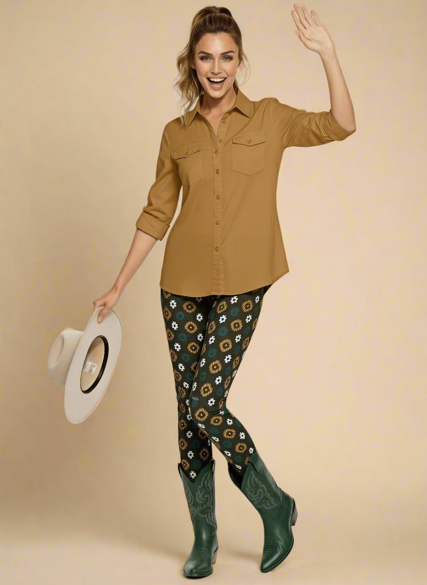 Model wearing Country Diamond Yoga Leggings with dark green base and white and yellow floral print, paired with forest green cowboy boots and a dusty mustard button-up blouse; outfit blends earthy tones with Western flair and modern activewear style.