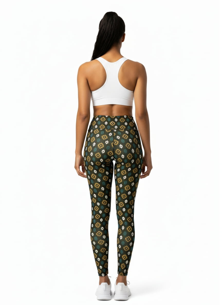 Woman wearing a white sports bra and green patterned leggings on a white background