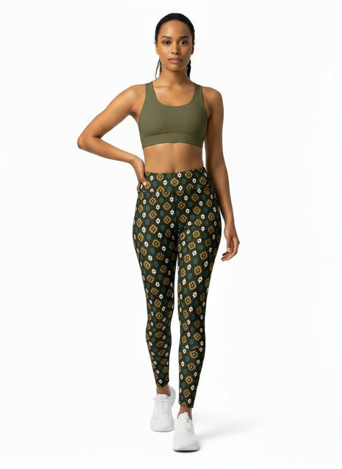 Woman wearing a green sports bra and patterned leggings on a white background