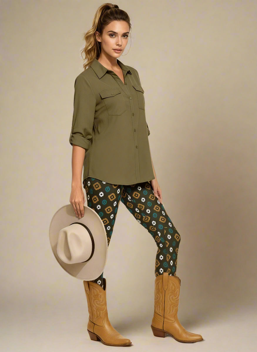 Model wearing Country Diamond Yoga Leggings with dark green base and white and yellow floral print, styled with mustard ochre cowboy boots and an olive green button-up blouse; outfit blends earthy tones with Western-inspired fashion and modern activewear.
