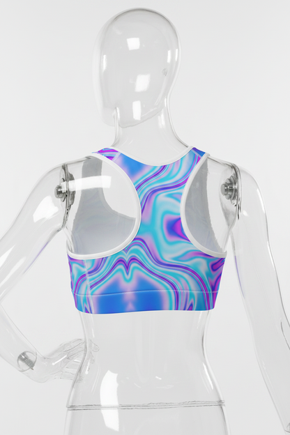 A racerback sports bra with a vibrant, multicolored psychedelic swirl pattern in shades of blue, purple, and pink, featuring solid white shoulder panels.