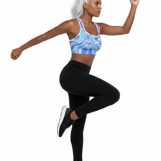 Woman wearing a colorful sports bra and black leggings on a white background