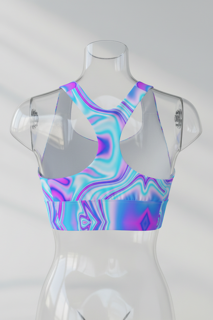 A women's sports bra with a vibrant, multicolor abstract fluid pattern in shades of blue, purple, and pink, featuring solid white underbust cups and racerback straps, shown against a plain white background.