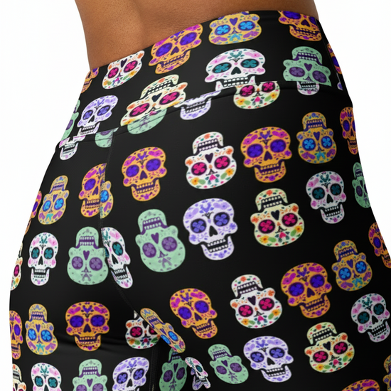 Colorful sugar skull pattern on black leggings worn by a person.