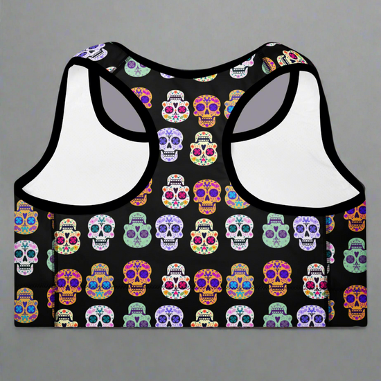 Black sports bra with colorful skull pattern on a gray background