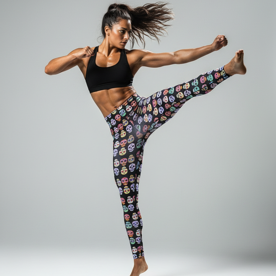 Woman in colorful patterned leggings and black sports bra posing dynamically on a gray background