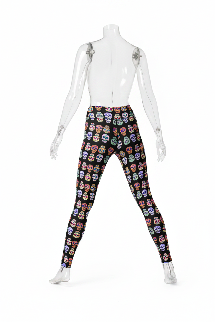 A person modeling high-waisted leggings with a black background and an all-over colorful sugar skull print, shown from the waist down against a plain white studio background.