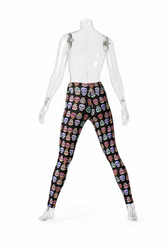 A person modeling high-waisted leggings with a black background and an all-over colorful sugar skull print, shown from the waist down against a plain white studio background.