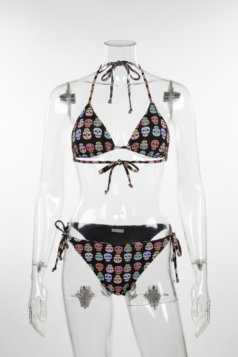 A two-piece  string bikini set featuring a black base printed with colorful sugar skull motifs, shown against a plain white background.