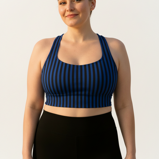 Woman wearing a blue and black striped sports bra and black leggings on a light gray background