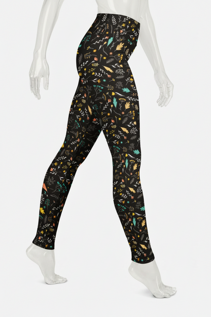A mannequin wearing high-waisted leggings with a black background and a dense multicolor botanical pattern of leaves, flowers, and birds, shown from the waist down against a plain white background.