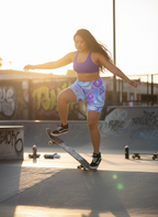 Person skateboarding in a skate park with graffiti in the background