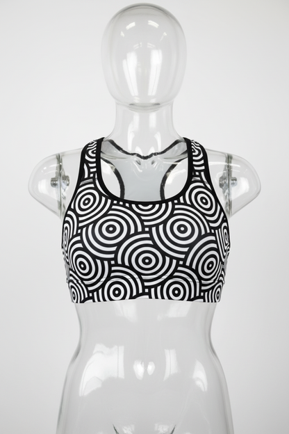 Black and white sports bra featuring a bold concentric circle target pattern, shown against a plain white background. 