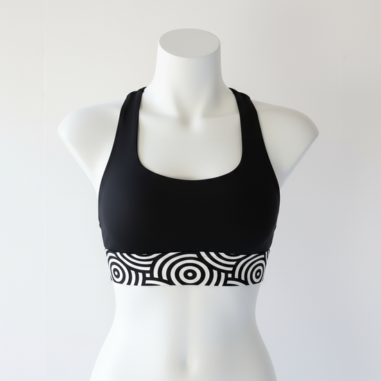 Black sports bra with white pattern on a mannequin against a white background