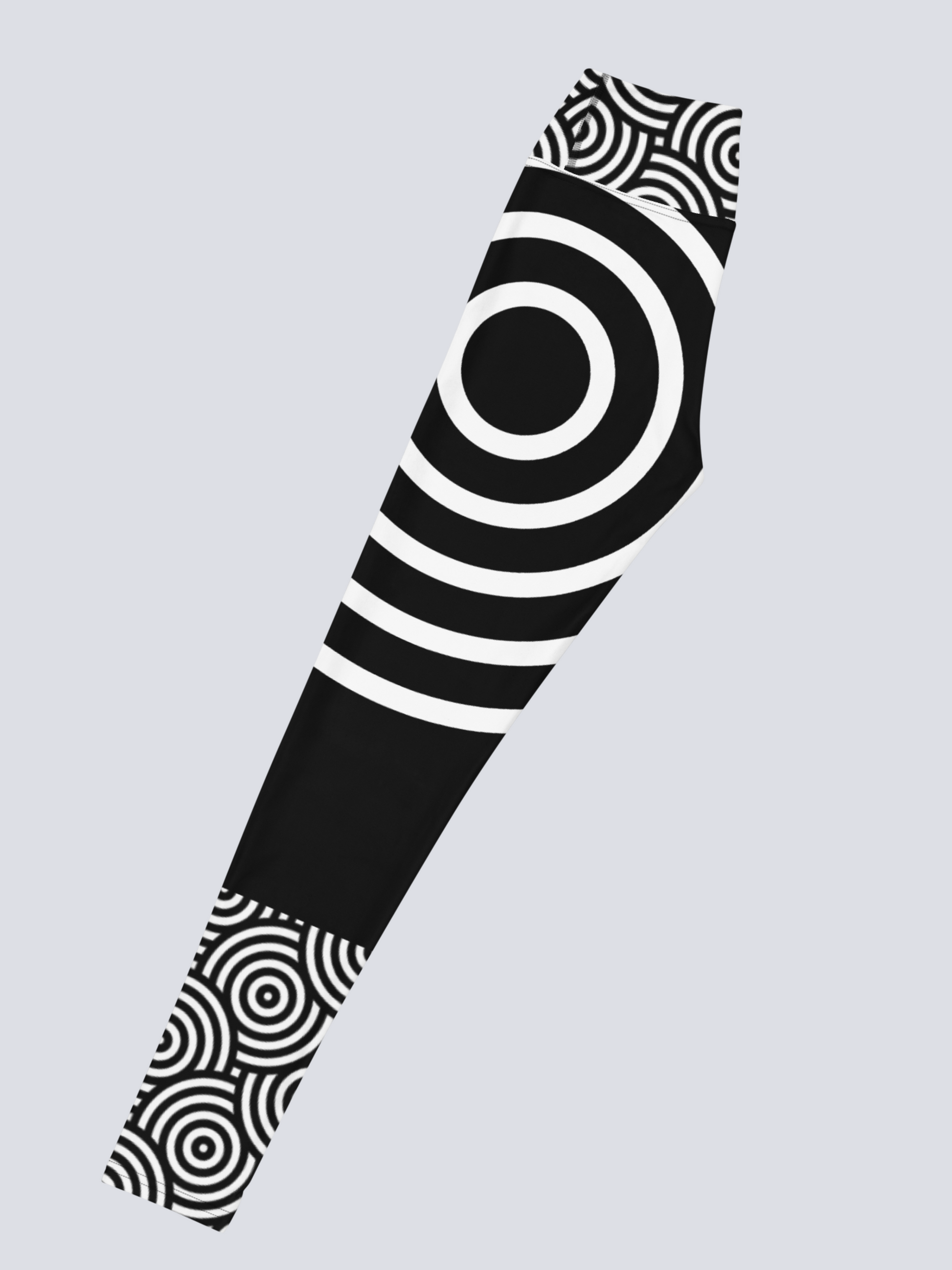 Left‑side view of black high‑waisted Lunar Loops yoga leggings with bold white concentric circle pattern, featuring large circular motif at mid‑thigh and smaller circles near waistband and ankle for a striking, modern look.