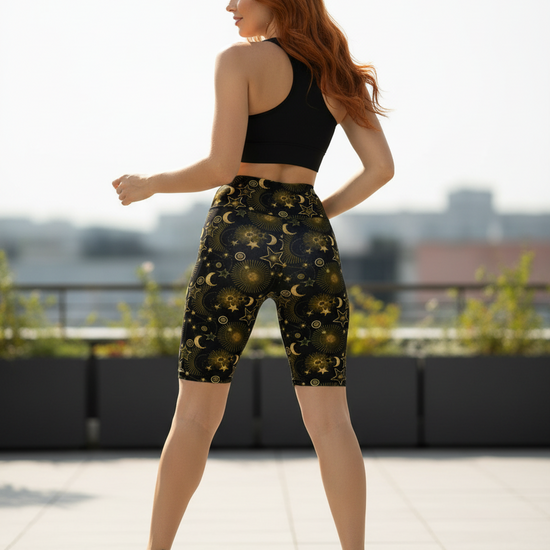 Woman wearing black sports bra and black shorts with celestial pattern.
