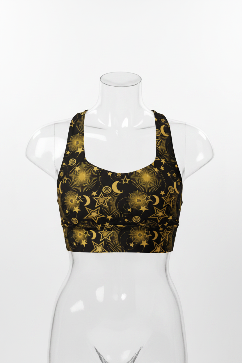 A mannequin modeling a black sports bra with a gold celestial pattern of stars and crescent moons, paired with black leggings, against a plain white background.