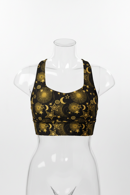 A mannequin modeling a black sports bra with a gold celestial pattern of stars and crescent moons, paired with black leggings, against a plain white background.