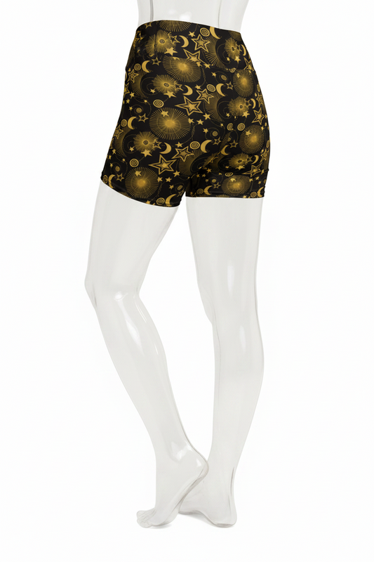 A mannequin wearing high-waisted black shorts with a gold celestial print of stars, moons, and planets, shown from the waist down against a plain white background.