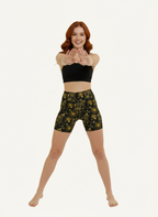 Woman wearing a black sports bra and camouflage shorts on a white background