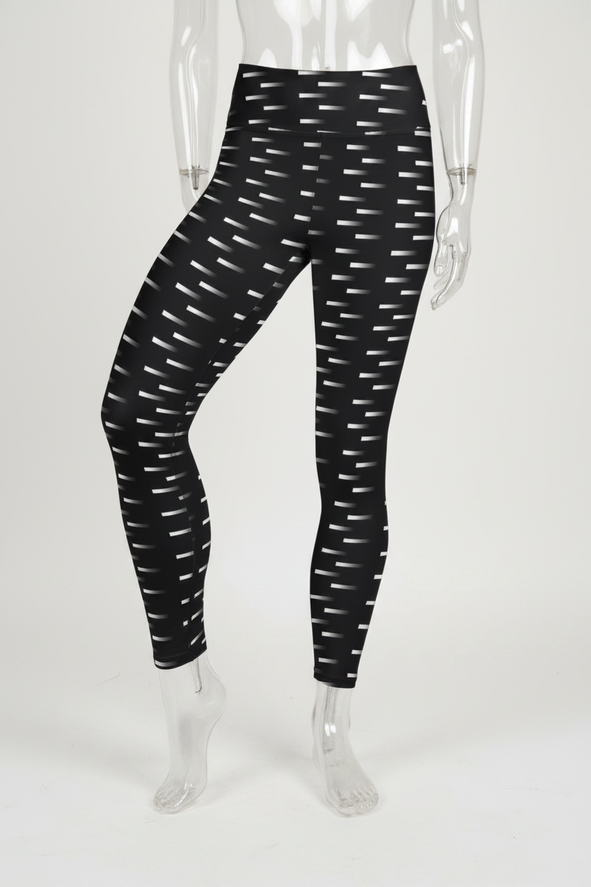 Black high-waisted leggings with a white geometric dash pattern, shown on a mannequin against a plain white background. 