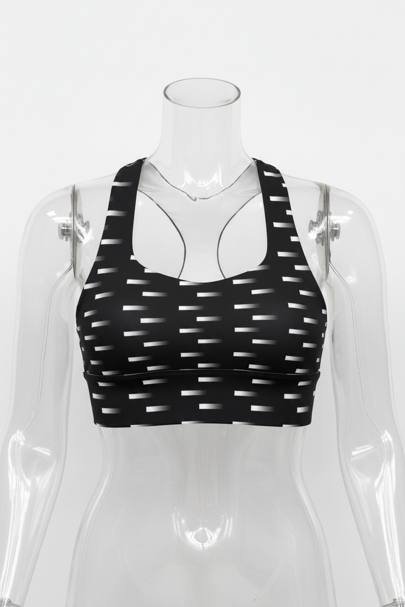 Black and white patterned sports bra with a geometric dash design, displayed on a solid white background. 