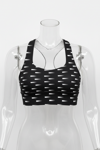 Black and white patterned sports bra with a geometric dash design, displayed on a solid white background. 