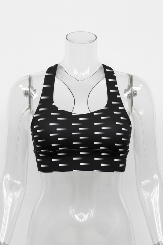 Black and white patterned sports bra with a geometric dash design, displayed on a solid white background. 