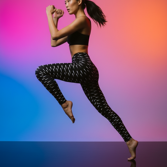 Woman in black athletic wear posing against a gradient background
