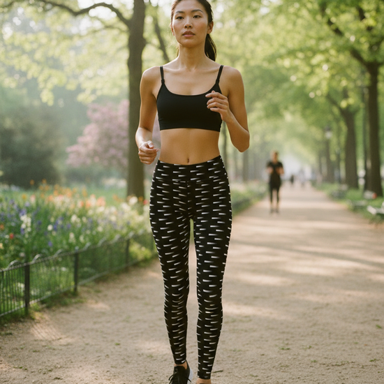 Woman jogging in a park with trees and flowers in the background