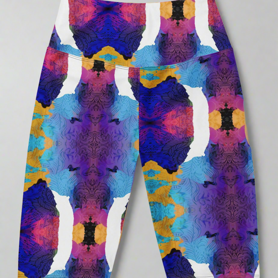 Front view, flat-lay of Ocean Mirage Biker Shorts featuring a vibrant abstract pattern in deep blue, purple, pink, orange, black, and white; displayed flat against a neutral grey background to highlight the bold kaleidoscopic design.